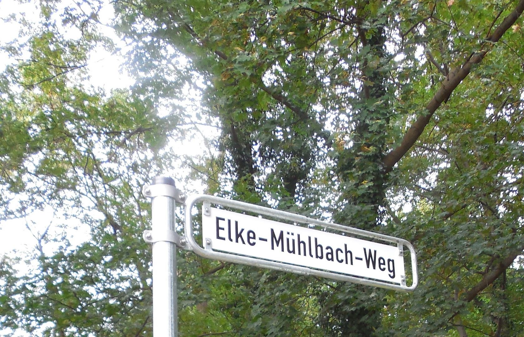 Das Foto zeigt ein Straßenschild am Weg zur Eilenriede beim Döhrener Turm. Auf dem Schild steht Elke Mühlbach Weg // the photo shows a sign at the way to the Eilenriede Forest near Döhrener Turm, the name on the sign is Elke Mühlbach Way