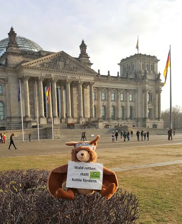 Das Photo zeigt Stofffledermaus Plüti vor dem Reichstag in Berlin 2018 mit der Botschaft: Stoppt die Braunkohle! // the photo shows soft toy bat Plüti in front of the Parlament Building in Berlin 2018 with his message to end coal